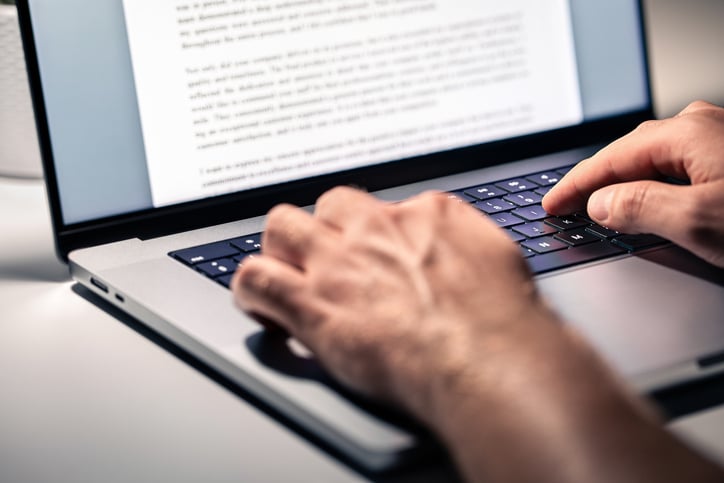 Un homme écrit un texte sur son ordinateur