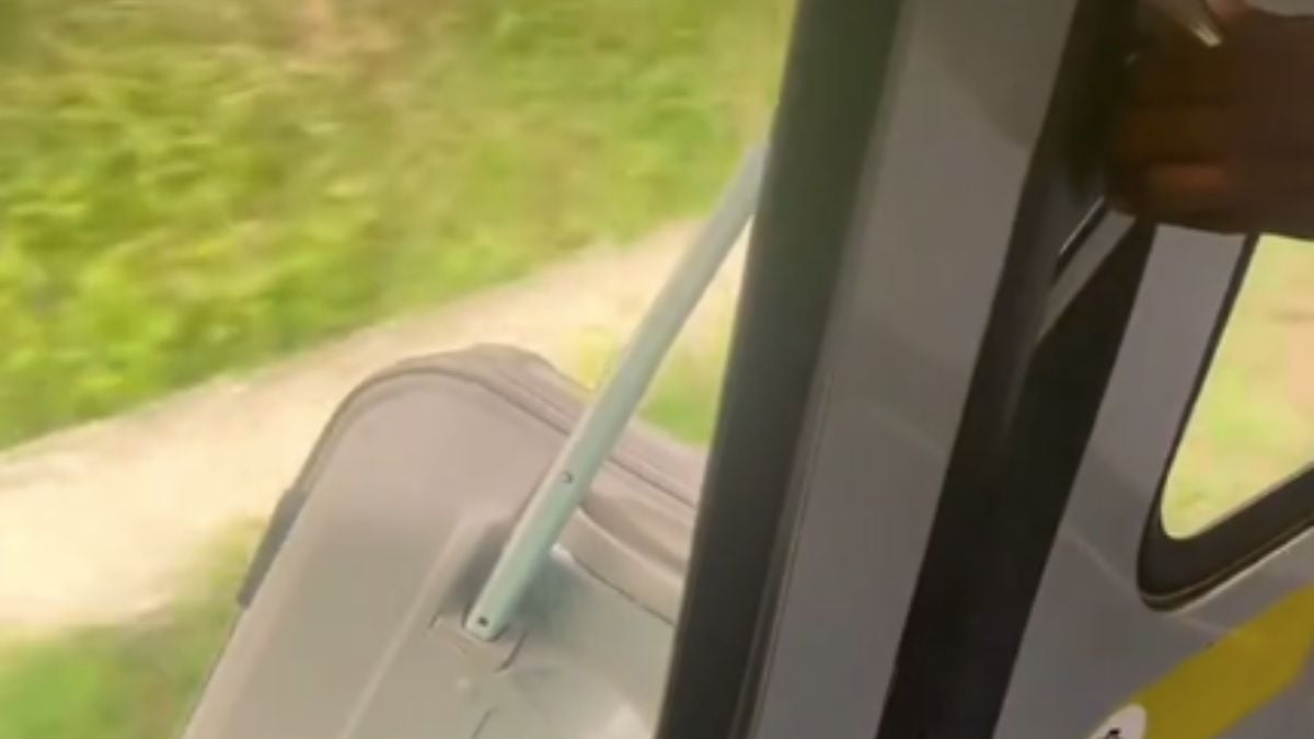 Un passager voyageant en train, avec sa valise coincée dans les portes