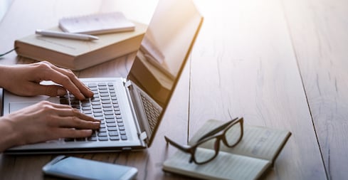 Un homme en train de taper sur le clavier de son ordinateur