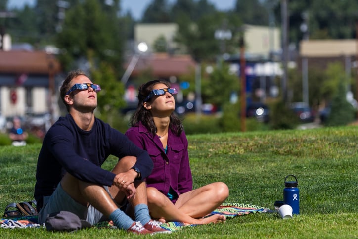 Deux personnes regardent une &eacute;clipse solaire