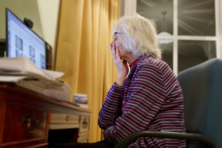 Une femme &acirc;g&eacute;e inqui&egrave;te devant son ordinateur