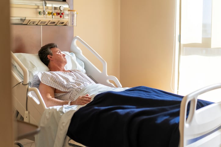 Un homme sur un lit d'h&ocirc;pital
