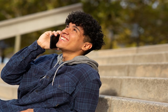 Un homme en train de rire au t&eacute;l&eacute;phone