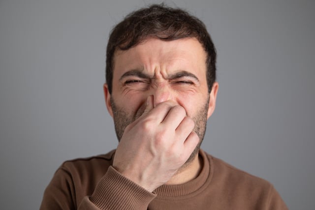 Un homme qui se bouche le nez