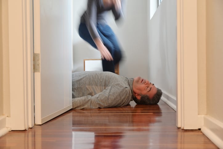 Une femme se penche sur son mari, inconscient