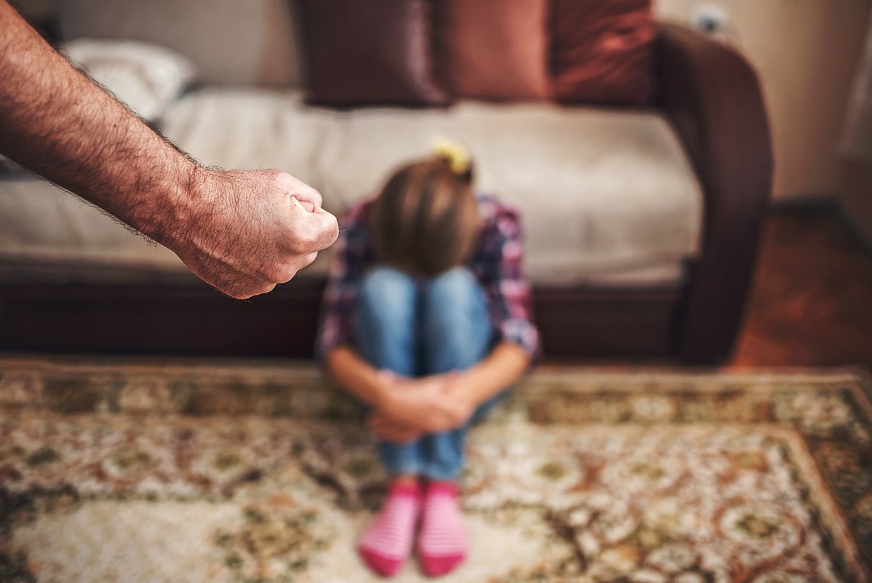 Un p&egrave;re s'appr&ecirc;tant &agrave; frapper sa fille adolescente 