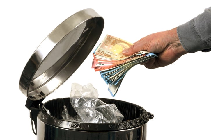 Une personne jette des billets &agrave; la poubelle