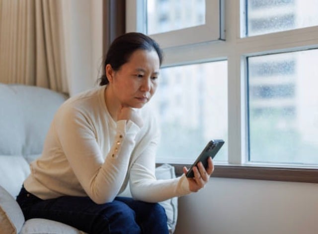Une femme d'origine asiatique qui attend un appel