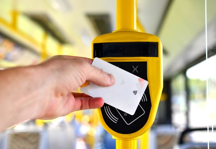Une personne paie par carte bancaire dans un bus