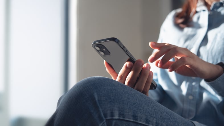 Une femme lisant un SMS re&ccedil;u sur son smartphone