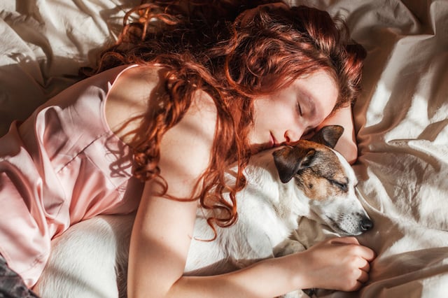 Une jeune fille qui dort avec son chien