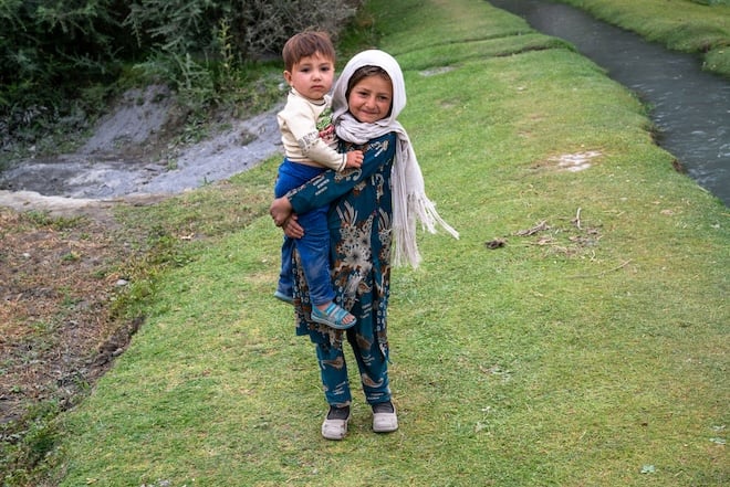 Fillette afghane portant son petit fr&egrave;re dans les bras