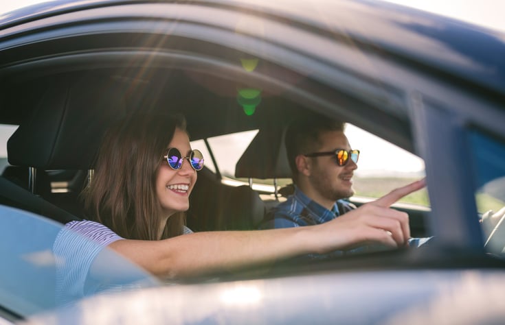 Un couple porte des lunettes de soleil en voiture