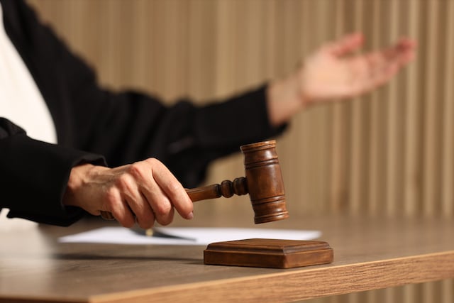 Un juge frappant le maillet sur une table en bois&nbsp;