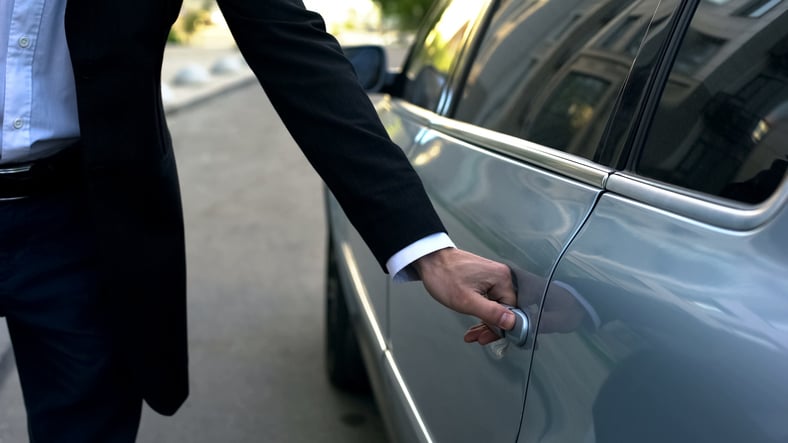 Un chauffeur de taxi ouvre la porte de la voiture