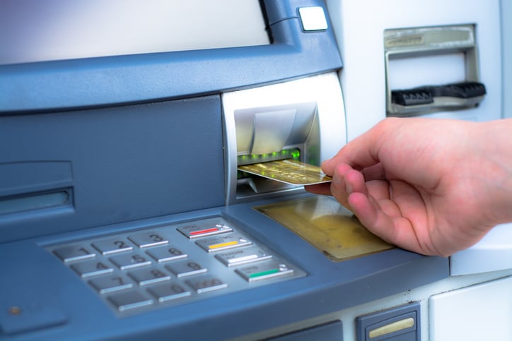 Une carte bancaire ins&eacute;r&eacute;e dans un distributeur de billets