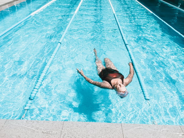 Une femme &acirc;g&eacute;e en train de nager dans une piscine