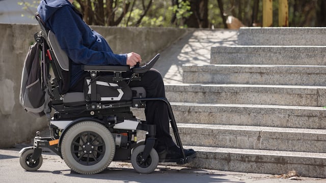 Un homme qui de d&eacute;place en fauteuil roulant &eacute;lectrique
