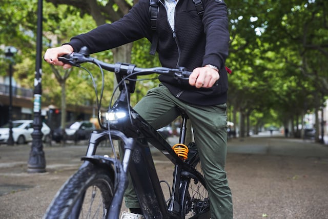 Un homme d'&acirc;ge m&ucirc;re se d&eacute;pla&ccedil;ant en v&eacute;lo &eacute;lectrique 