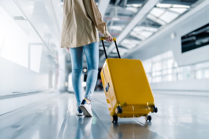 Une femme marche avec sa valise
