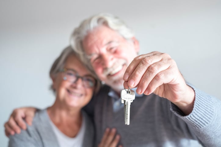 Un couple de personnes &acirc;g&eacute;es avec les cl&eacute;s d'un logement