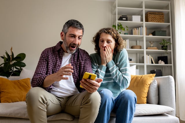 Un couple sous le choc en consultant leur portable