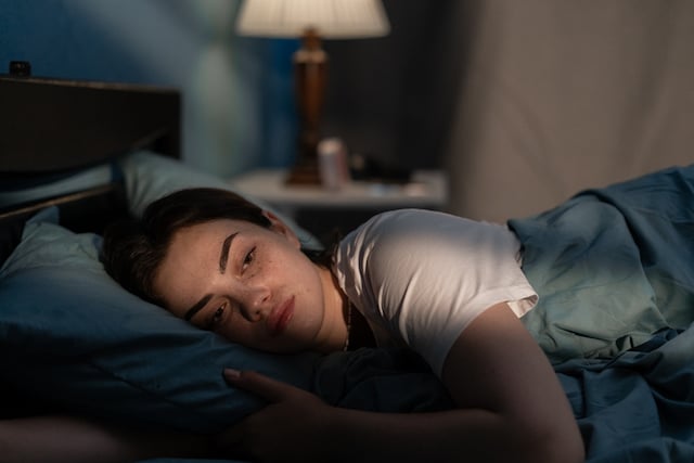 Une jeune femme souffrant d'insomnie dans son lit
