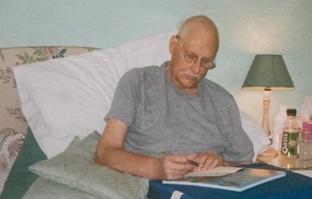 Philip, le père de famille, en train d'écrire des lettres destinés à sa fille