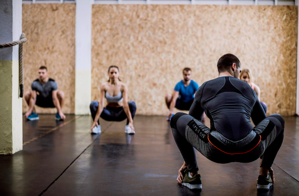 Un groupe de sportifs font des squats au repos