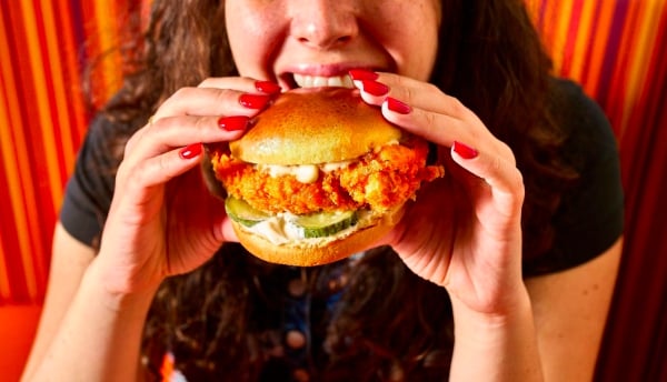 Une cliente de Popeyes en train de savourer un sandwich