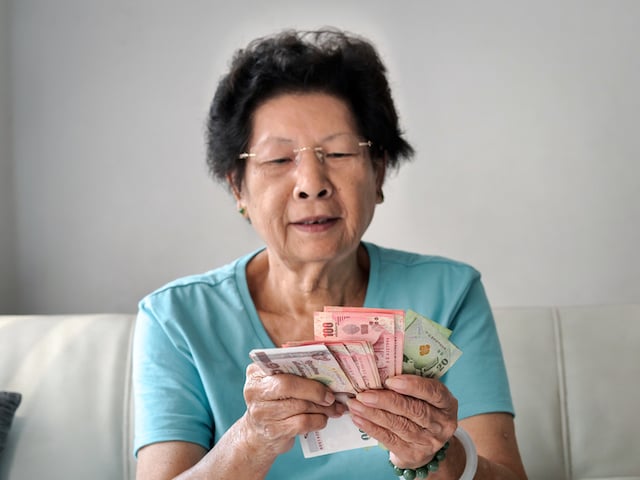 Une retraitée japonaise en train de compter des billets