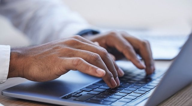 Gros plan sur des mains en train de taper sur un clavier