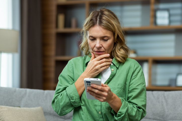 Une femme concentr&eacute;e devant son t&eacute;l&eacute;phone