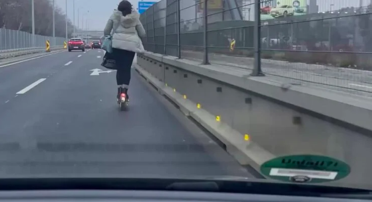 Une femme en trottinette fait un doigt d'honneur &agrave; un automobiliste