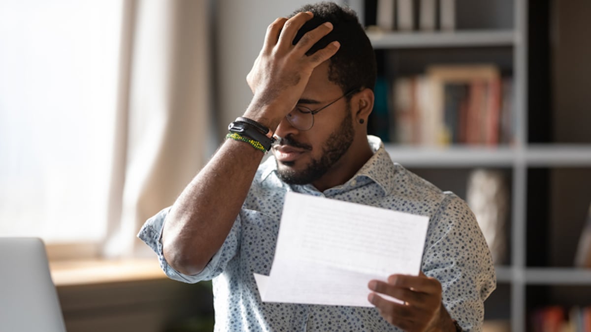 Un homme ouvre son courrier avec d&eacute;pit