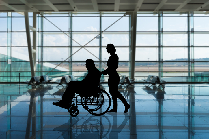 Une personne en fauteuil roulant dans un a&eacute;roport
