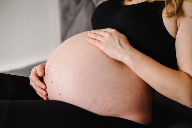 Une femme enceinte en train de toucher son ventre