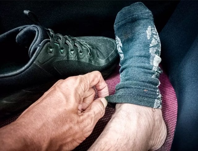 Un homme en train de retirer sa chaussette