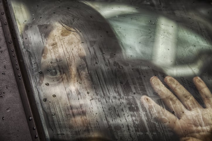 Une jeune femme apeur&eacute;e &agrave; la fen&ecirc;tre d'une voiture