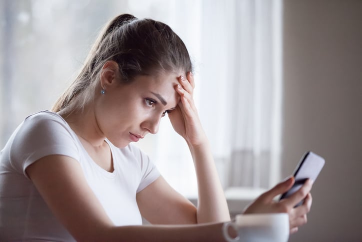 Une femme anxieuse devant son smartphone