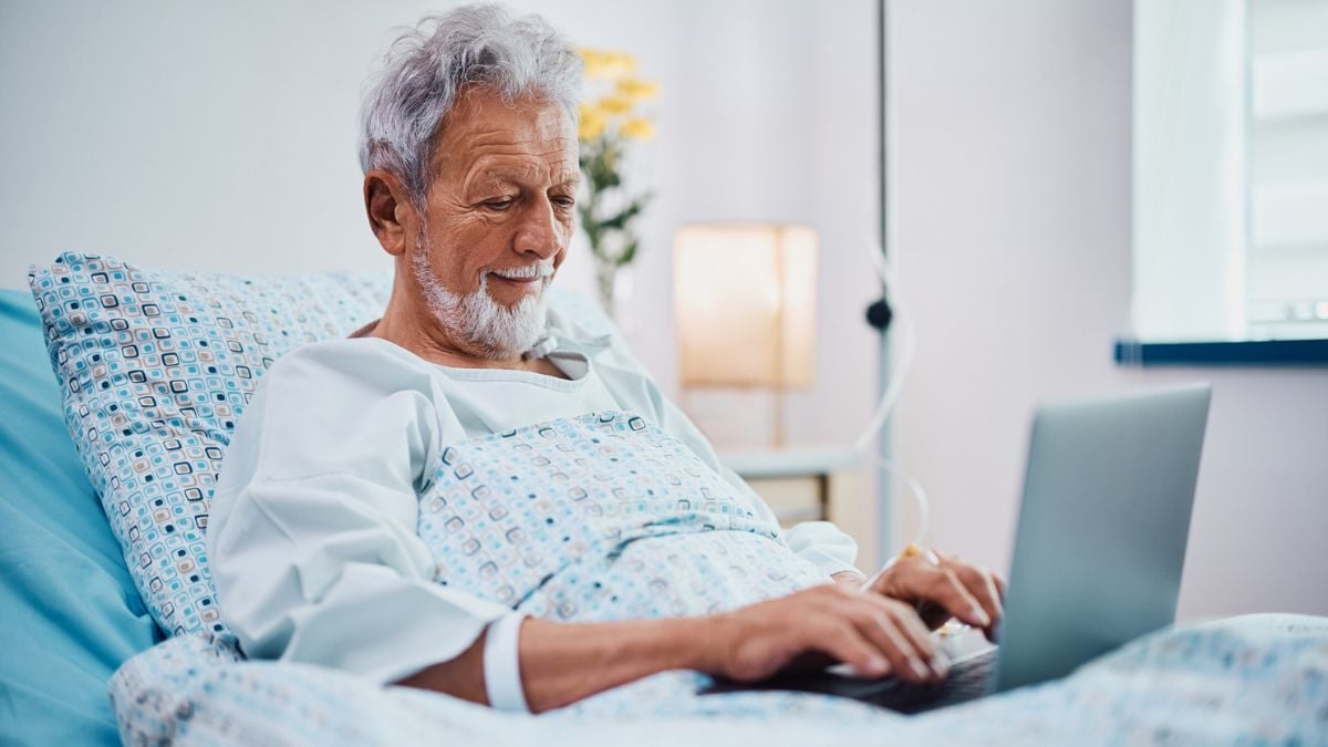Un homme surfant sur internet sur son lit d'hôpital