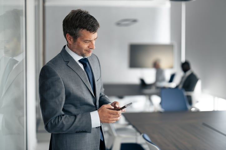 Un homme utilise son t&eacute;l&eacute;phone au travail