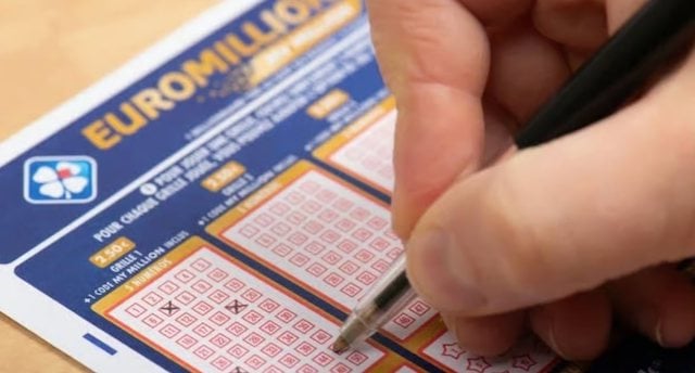 Une personne en train de remplir une grille EuroMillions 