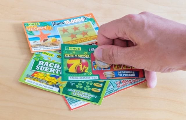 Un homme en train de gratter des jeux de grattage