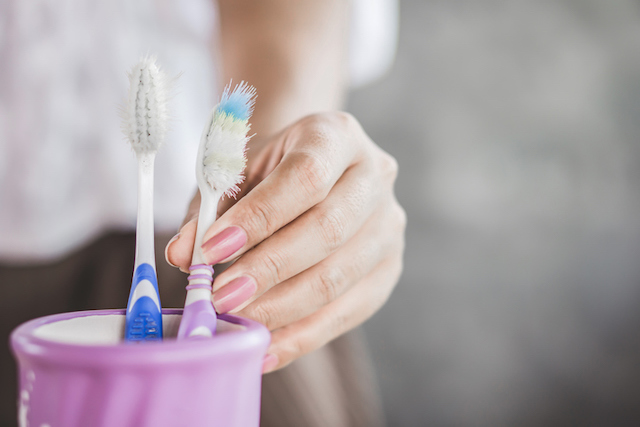 Une femme qui attrape une brosse &agrave; dents