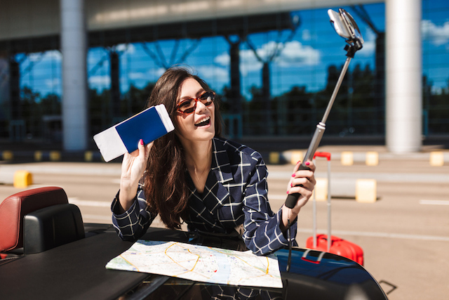 Une femme qui utilise une perche &agrave; selfie