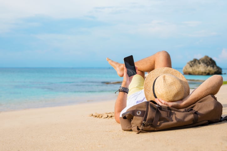 Un homme sur son t&eacute;l&eacute;phone sur la plage