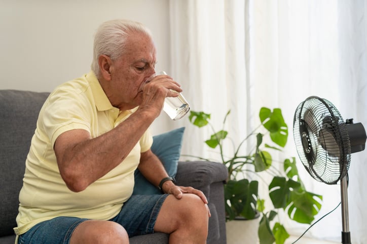 Un homme &acirc;g&eacute; boit de l'eau