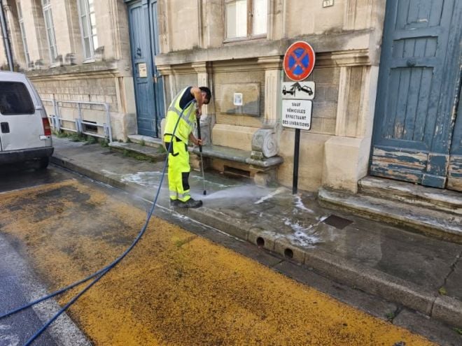 Un agent d'entretien nettoie le banc