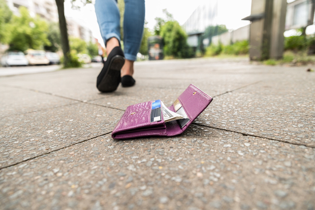 Une femme qui a fait tomber son porte-feuille dans la rue